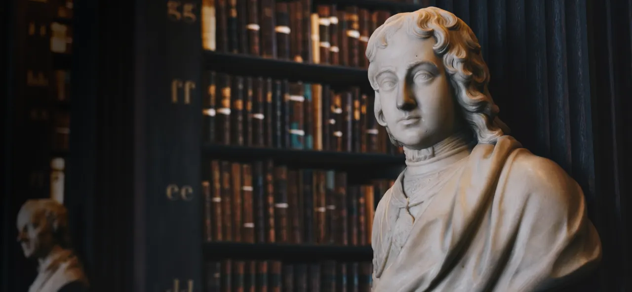 Old library with bookshelves and marble statue